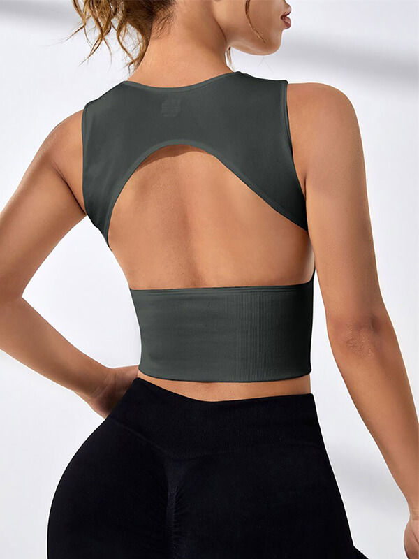 Woman wearing a backless short tank top ideal for pilates, showcasing breathable and quick-drying fabric, perfect for yoga.